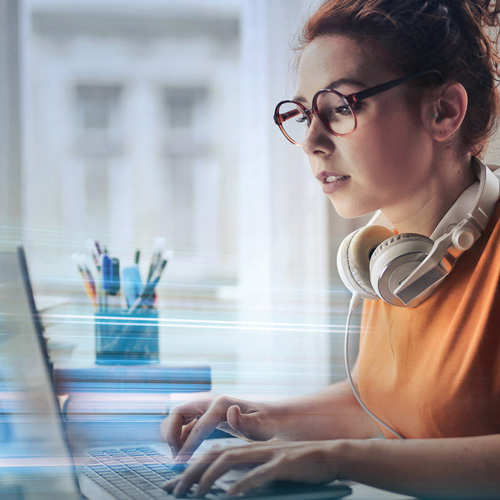 Eine Frau sitzt am Laptop und testet ihre Internetgeschwindigkeit.