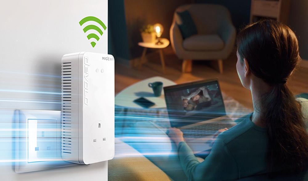 devolo adapter powerline Magic 2 WiFi 6 in the wall socket. In the background a girl is siting on a couch and streaming.