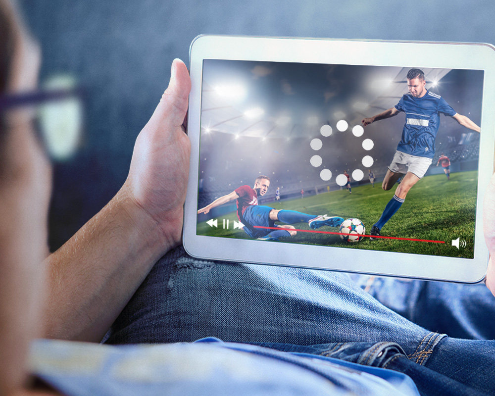 Ein Mann schaut Fußball auf einem Tablet. Der Livestream ist stehengeblieben und lädt.