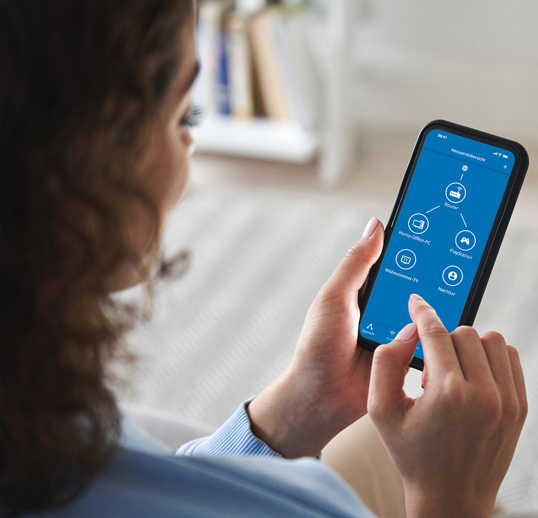 Eine Frau blickt auf ein Smartphone-Display, das die verbundenen Geräte eines Heimnetzwerks zeigt.