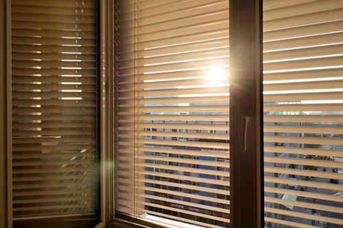 Ein Fenster mit Rolladen und die Sonne scheint dadurch