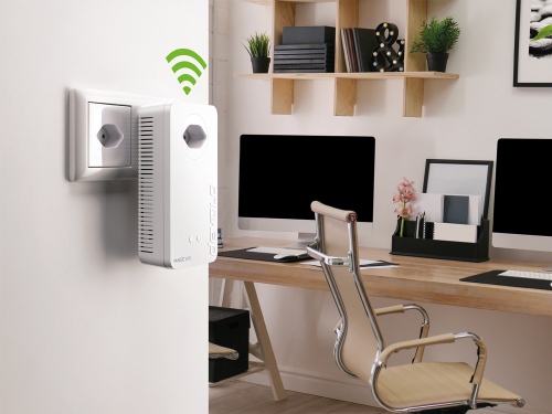 Un adaptateur CPL devolo Magic 2 WiFi 6 avec ondes WiFi est branché sur une prise dans un bureau à domicile.